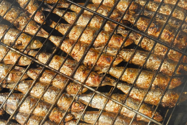 Des sardines grillées sur une grille métallique alors qu'elles grillent sur un feu