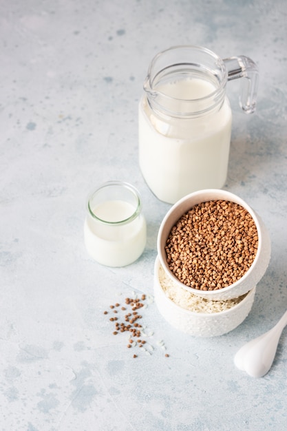 Sarrasin et riz dans des bols blancs et un pot à lait. Petit-déjeuner sain.