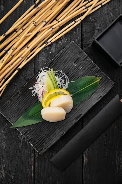 Sashimi sur une assiette sur une table sombre Cuisine japonaise