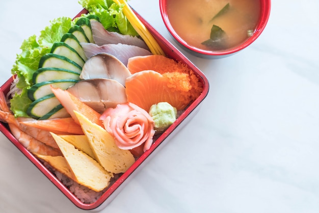 Sashimi frais cru avec du riz dans une boîte à bento