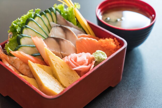 Sashimi frais cru avec du riz dans une boîte à bento