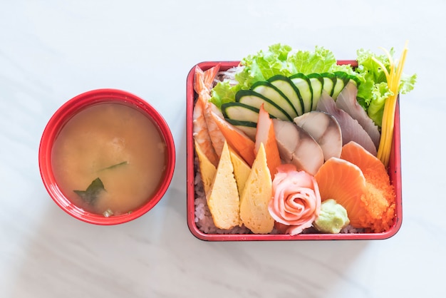 Sashimi frais cru avec du riz dans une boîte à bento