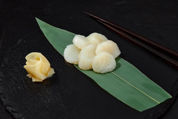 Sashimi de poulpe frais sur feuille de bambou sur fond noir