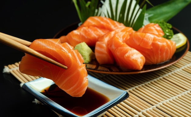 Sashimi saumon baguettes alimentaires japonaises et wasabi sur la table en boisxA