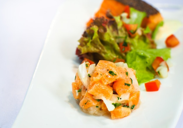 Sashimi De Saumon Servi Avec Une Salade Sur Des Assiettes Blanches.