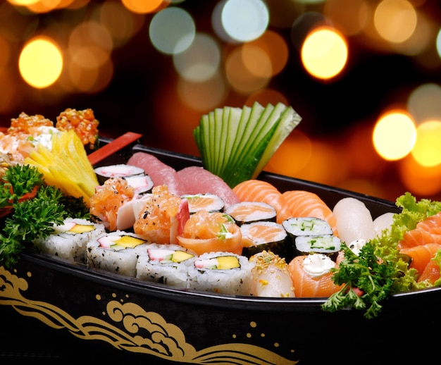 Photo sashimi de sushi dans un bateau en bois sur une table en bois marron. avec air, crevettes, crevettes, gingembre
