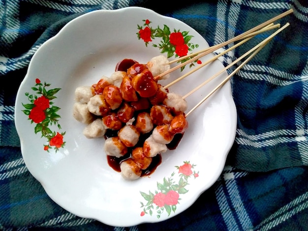Photo satay cilok ou boule de viande à la vapeur collante servir avec de la sauce chili sur une assiette cuisine culinaire indonésienne