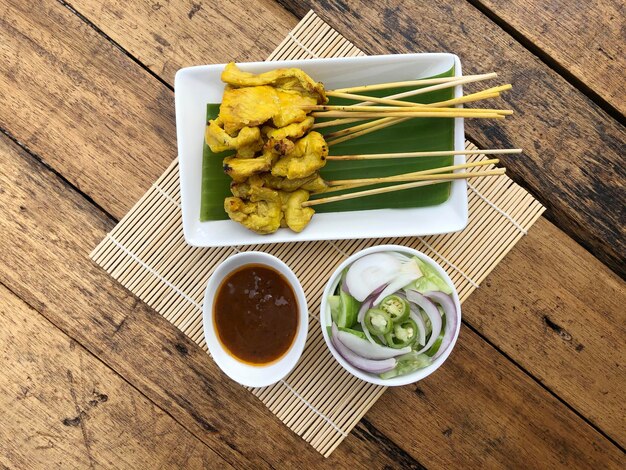 Photo satay de porc, porc grillé servi avec sauce aux cacahuètes ou sauce aigre-douce