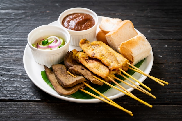 Satay de porc avec sauce aux arachides et cornichons