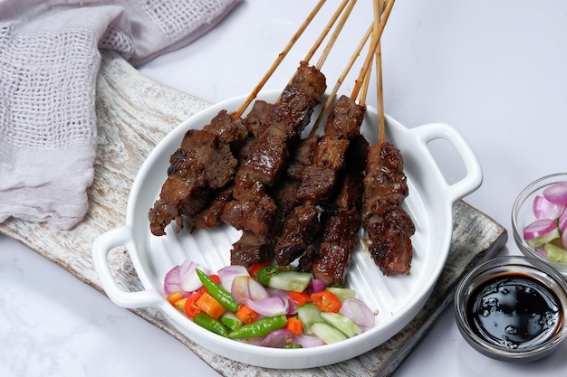 satay ou sate brochettes et viande grillée, servi avec salade épicée, concombre, piment et sauce soja,