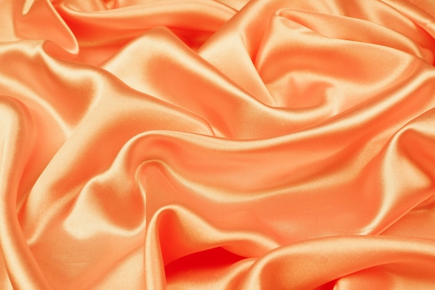 Photo satin luxueux de texture de soie orange belle pour l'abstrait, texture de tissu