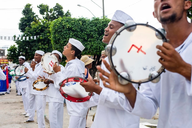 Saubara Bahia Brésil 03 août 2019 Hommes femmes et enfants membres du groupe culturel Cheganca dos Marujos dansent et chantent en costumes lors d'un spectacle dans les rues de Saubara Bahia