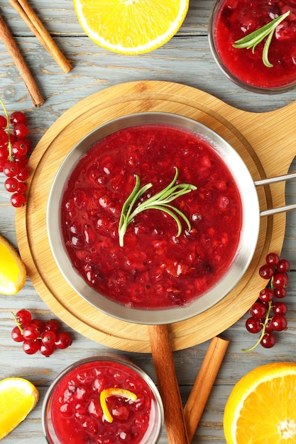 Sauce aux canneberges et ingrédients sur table en bois gris