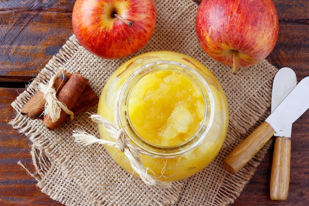 Sauce aux pommes maison ou purée de pommes dans un bol en verre sur la vue de dessus de table en bois rustique