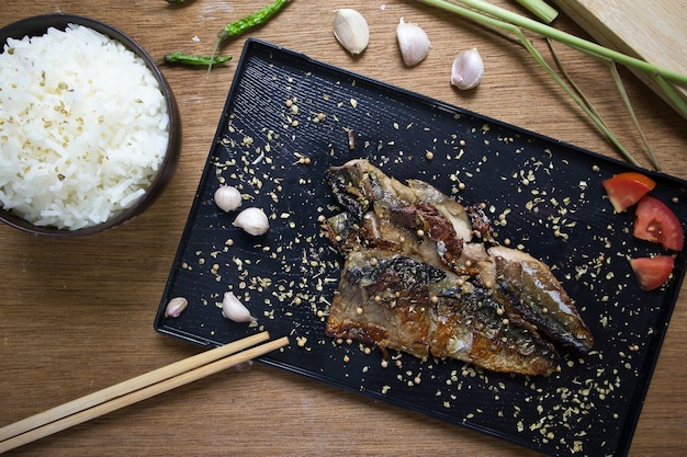 Sauce barbecue Saba avec une tasse de riz cuit sur une table en bois