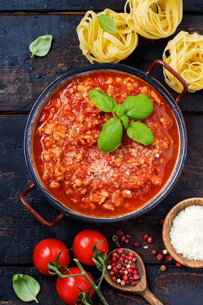 Sauce bolognaise italienne traditionnelle dans une casserole un vieux fond en bois foncé