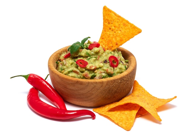 Sauce dip guacamole dans un bol en bois et chips de nachos isolés sur fond blanc