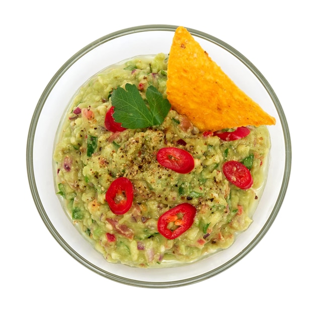 Sauce dip mexicaine guacamole biologique végétarienne saine servie dans un bol en verre avec des nachos ou des chips de tortilla isolés sur fond blanc