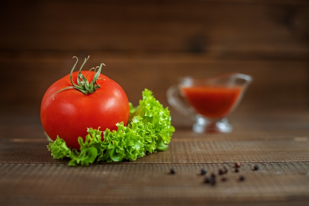 Sauce, laitue et tomates sur un bois. une alimentation saine et le végétarisme.