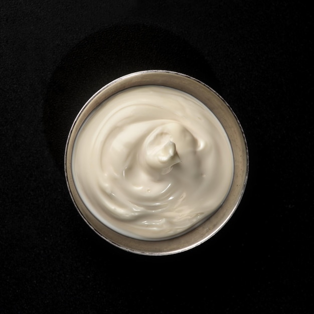 Sauce mayonnaise dans une saucière en métal sur fond noir pour la restauration rapide