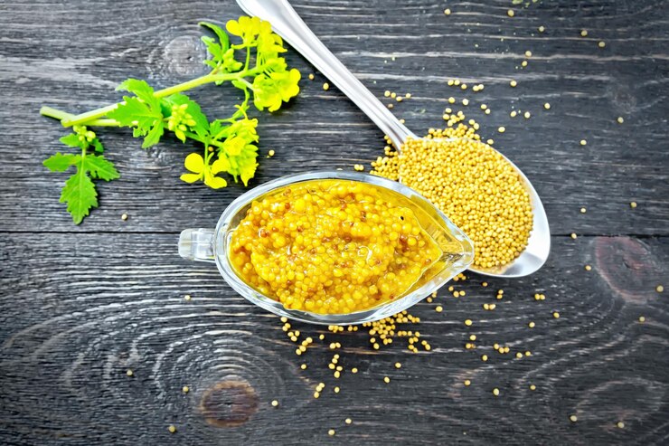 Photo sauce moutarde dijon en saucière avec fleur à bord dessus