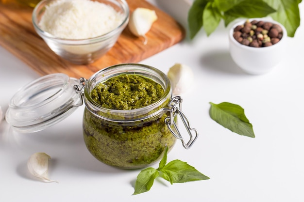 Sauce pesto au basilic en bocal. Ingrédients pour la cuisine, fromage, parmesan, ail, huile d'olive.