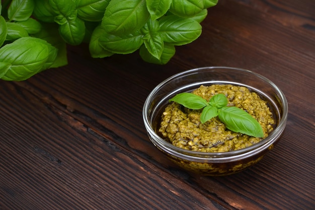 Sauce pesto dans un bol en verre sur fond de bois