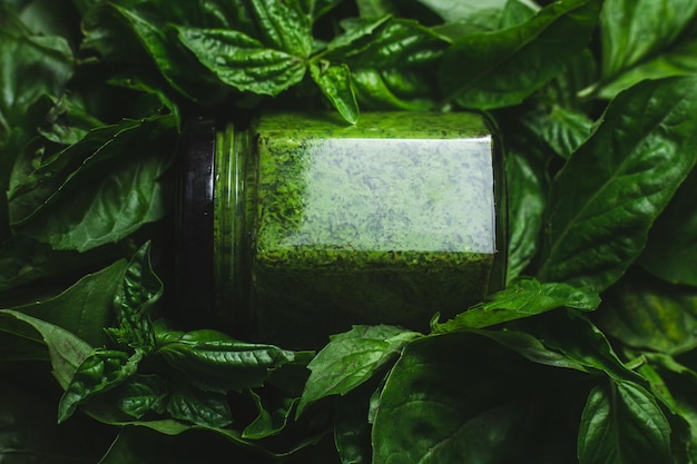 Sauce pesto dans un pot de verre avec des feuilles de basilic vert