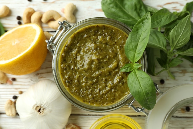 Sauce pesto et ingrédients pour la cuisson sur fond de bois