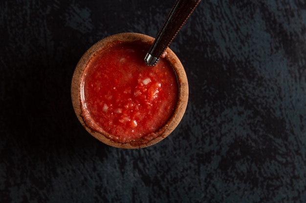 sauce piquante dans un pot en bois et sauce rouge cuillère