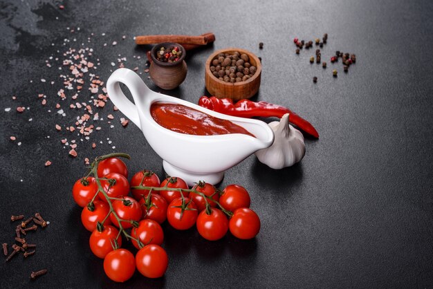 Sauce rouge ou ketchup dans un bol et ingrédients pour la cuisson