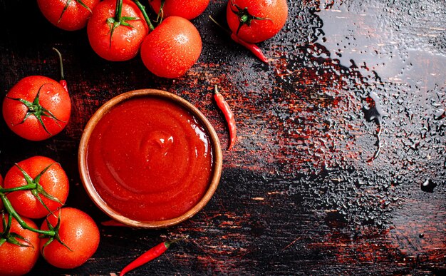 Sauce tomate dans une assiette avec des plateaux de poivrons rouges