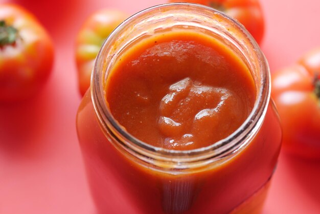 Sauce tomate dans un petit pot avec tomate fraîche sur table