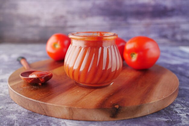 sauce tomate dans un petit pot avec des tomates fraîches sur la table