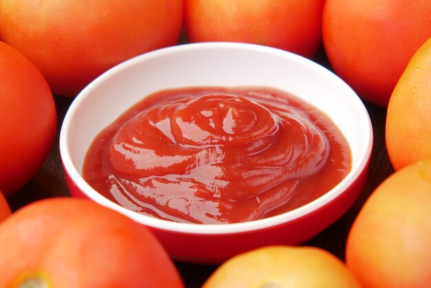 sauce tomate dans un petit pot avec des tomates fraîches sur table