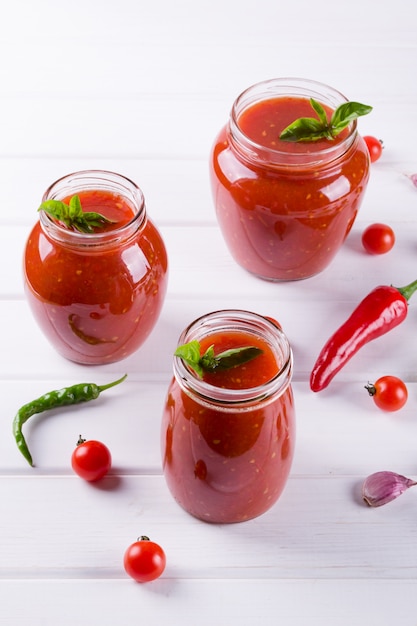 Sauce tomate douce épicée à l'ail, au poivre et aux herbes dans des bocaux en verre.