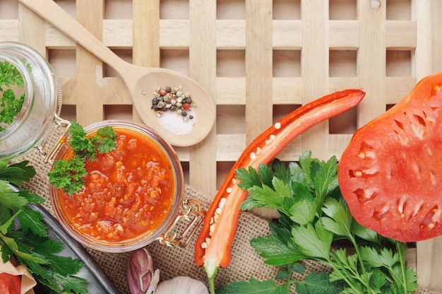 Sauce tomate et ingrédients pour sa cuisson sur un plat en métal. Vue de dessus.