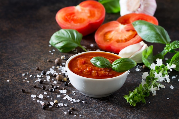 Sauce tomate ketchup dans un bol avec des feuilles de basilic