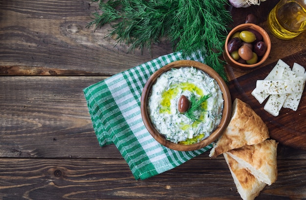 Sauce tzatziki dans un bol sur fond de bois rustique Cuisine grecque Nourriture végétarienne saine Vue de dessus