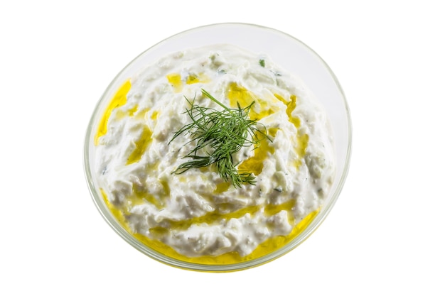 Sauce tzatziki dans un bol en verre isolé sur fond blanc.