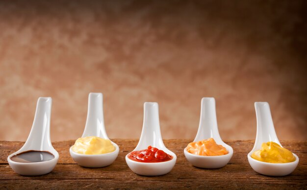 Sauces mélangées dans les cuillères en céramique