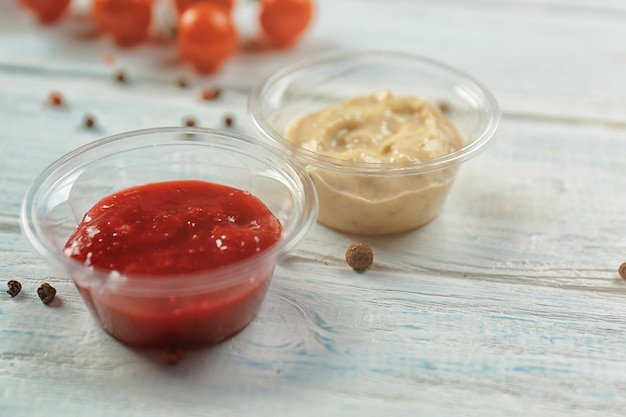 Sauces savoureuses dans des bols en plastique sur la table