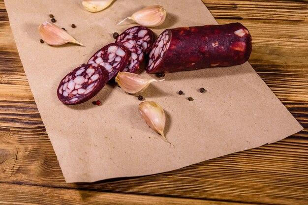 Saucisse et ail de salami coupés en tranches sur un papier d'emballage brun