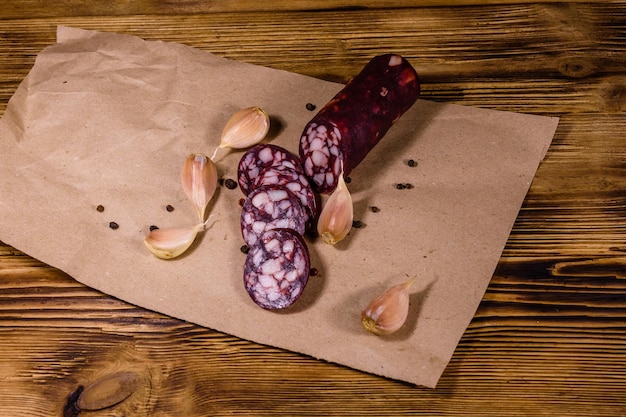 Saucisse et ail de salami coupés en tranches sur un papier d'emballage brun