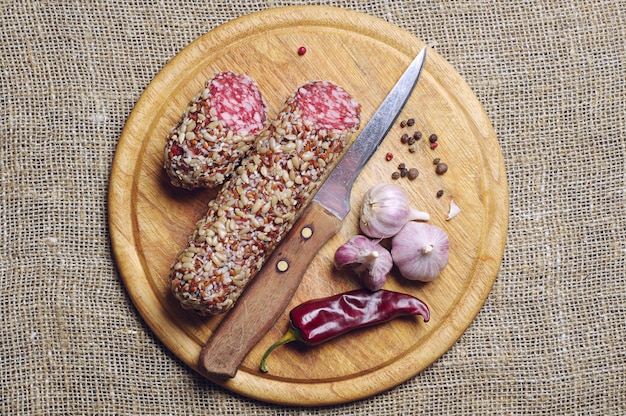 Saucisse aux graines de tournesol, piment rouge et ail sur planche à découper