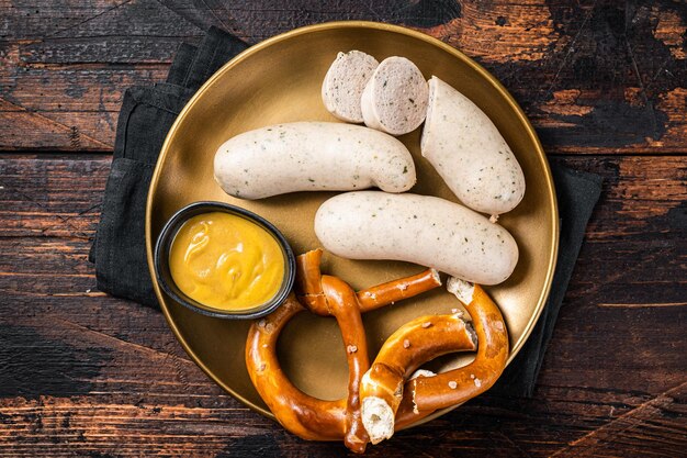 Saucisse blanche de Munich avec bretzel et moutarde Fond en bois Vue de dessus