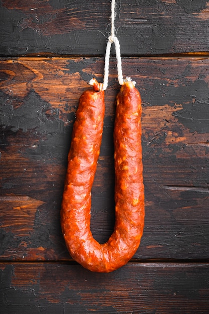 Saucisse chorizo espagnole traditionnelle sur la vieille table en bois, vue de dessus.