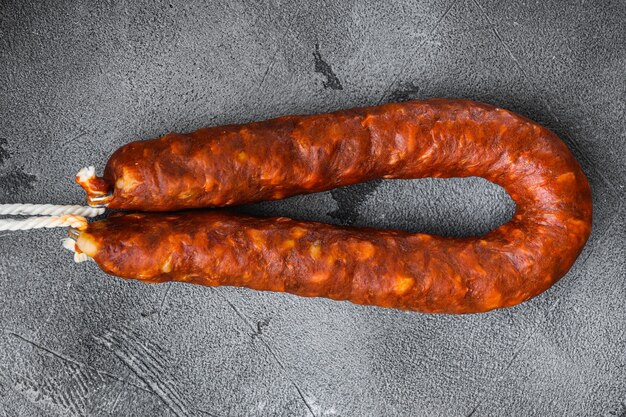 Saucisse chorizo salami sur fond gris.