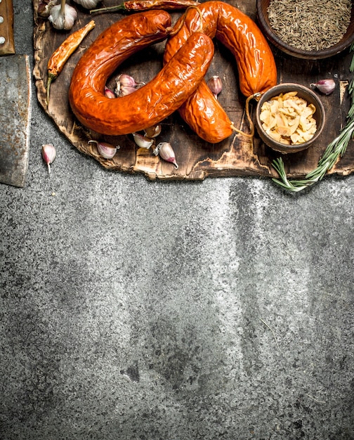 Saucisse de Cracovie aux épices et à l'ail sur le plateau. Sur un fond rustique.