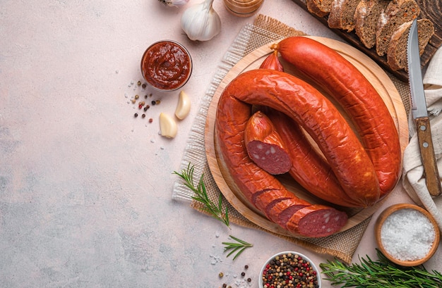 Saucisse de Cracovie aux épices, sauce et pain sur fond clair. Vue de dessus, copiez l'espace.